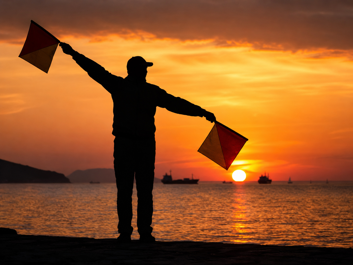 Person using semaphore flags at sunset
